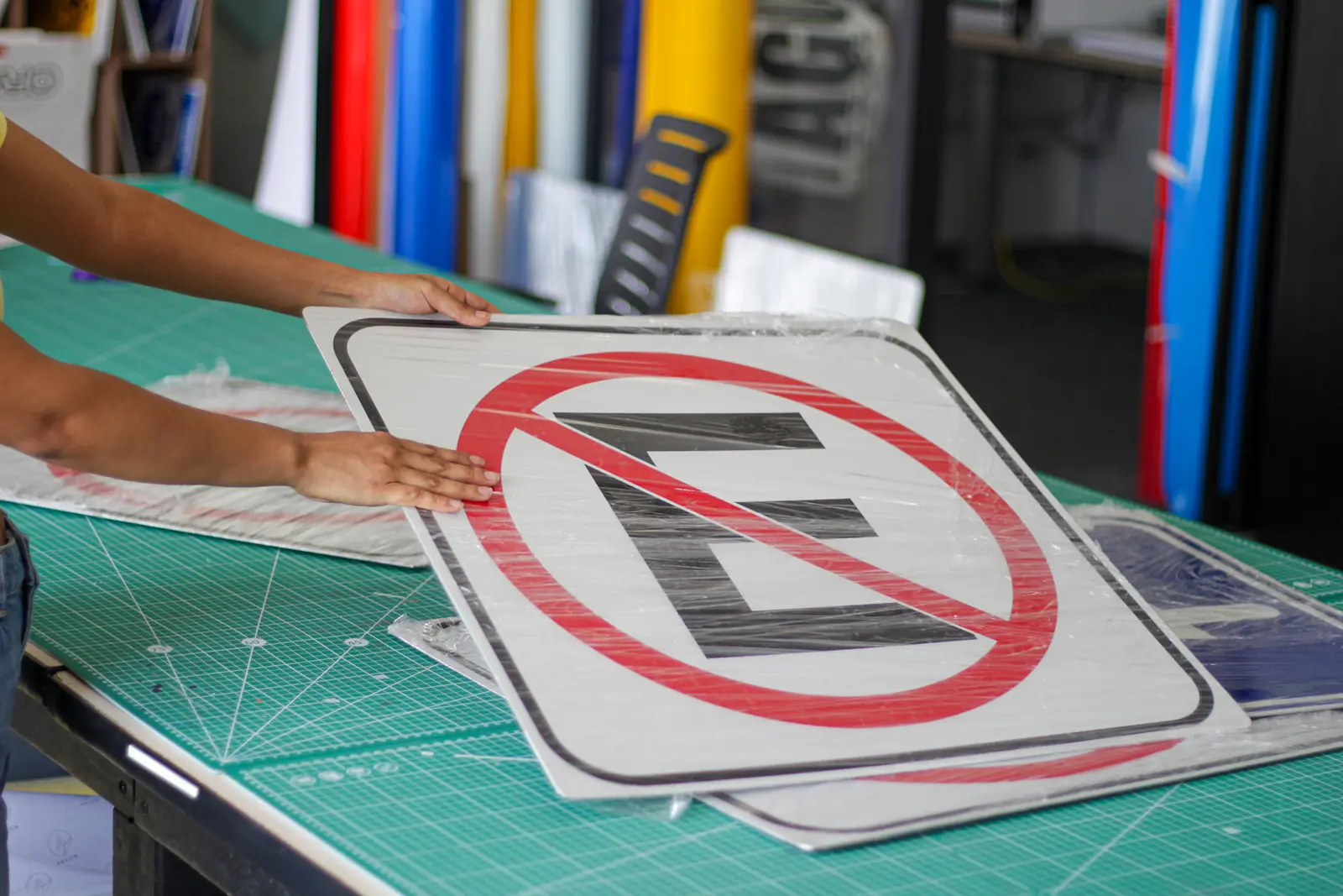 Personal de Nyne Print sosteniendo un señalamiento recién producido en el taller